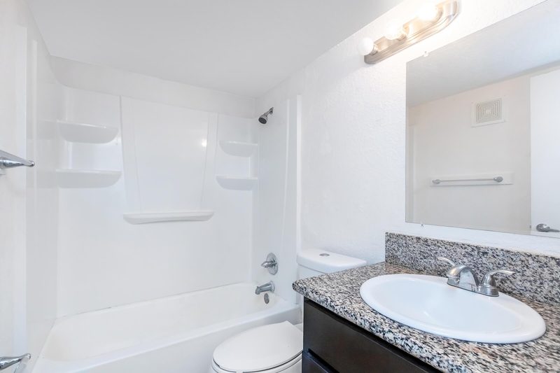 Bathroom with shower-tub combination and large mirror