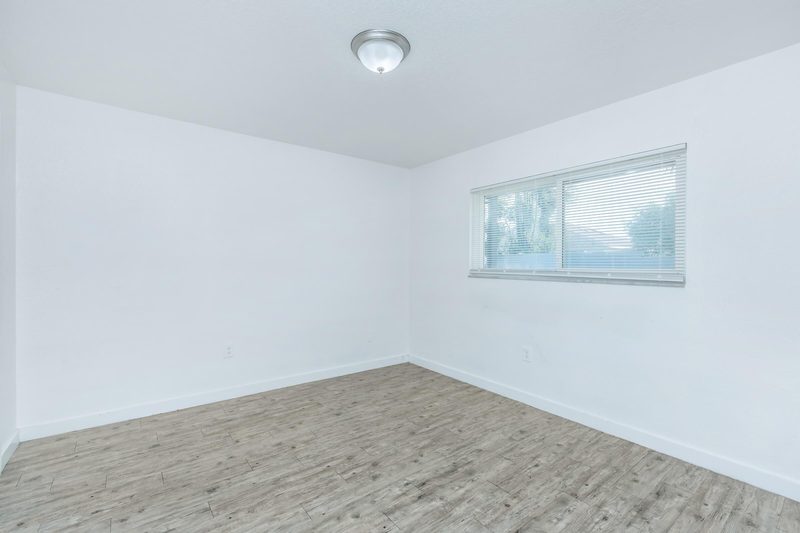 Second bedroom with natural light and wood-style flooring