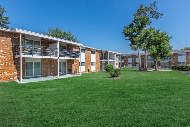 Two-story brick apartment buildings with mature landscaping